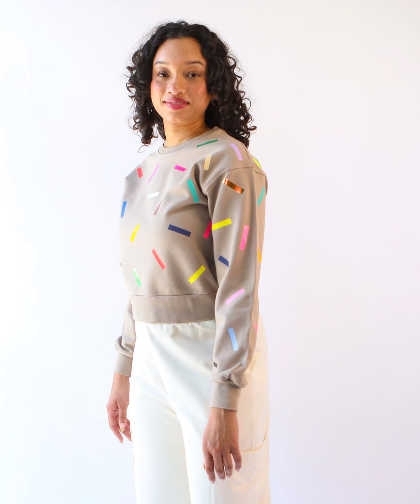 Woman wearing a 100% cotton sweatshirt with colorful sprinkles pattern in beige