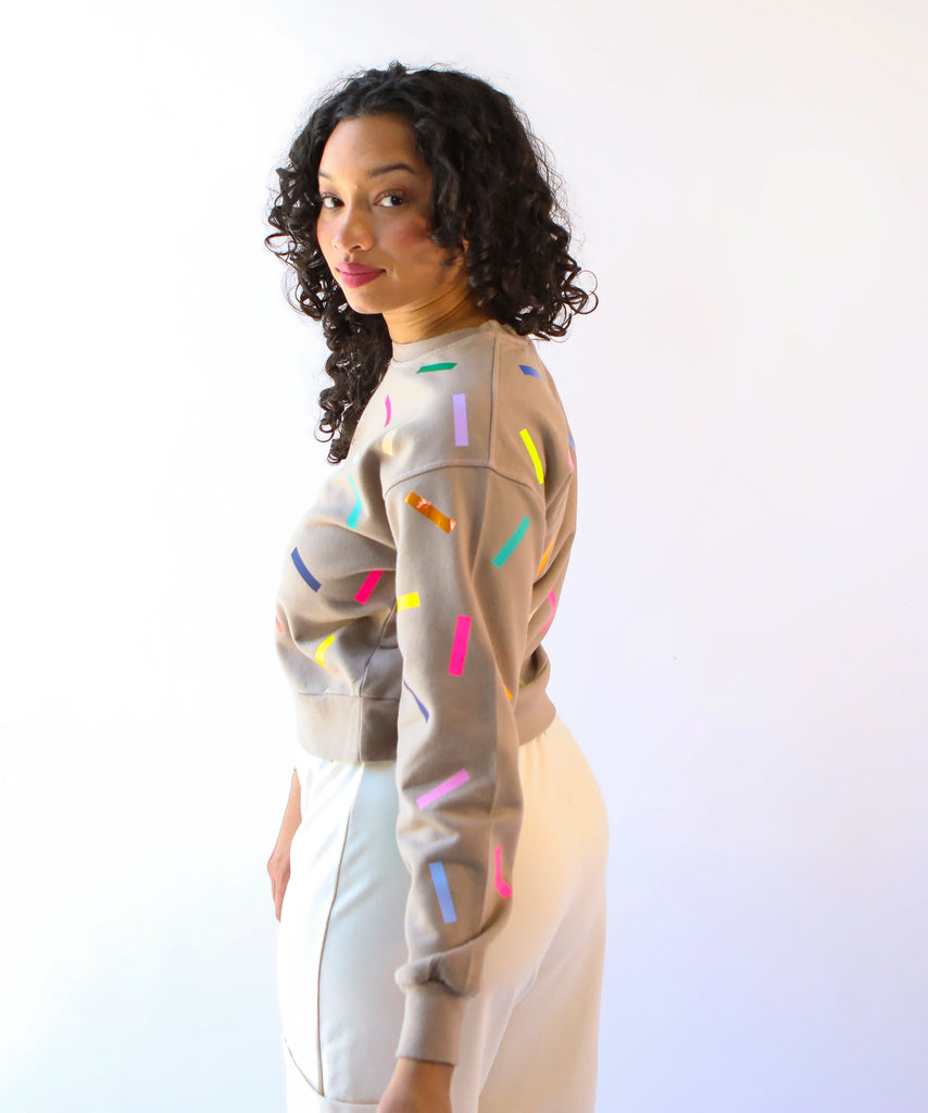 Woman wearing a 100% cotton sweatshirt with colorful sprinkles pattern in beige
