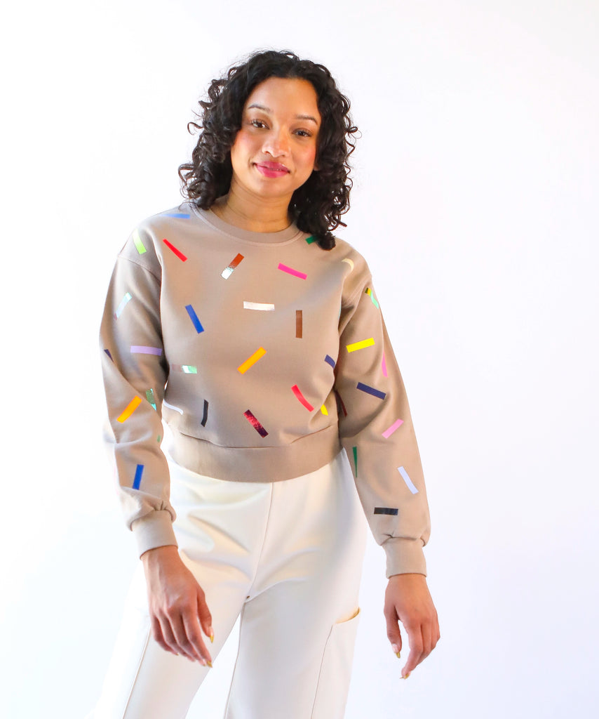 Woman wearing a 100% cotton sweatshirt with colorful sprinkles pattern in beige