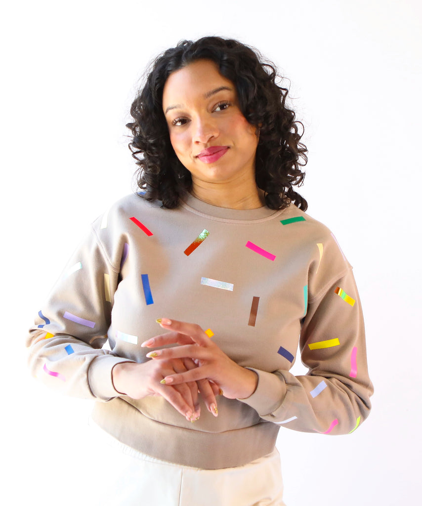 Woman wearing a 100% cotton sweatshirt with colorful sprinkles pattern in beige