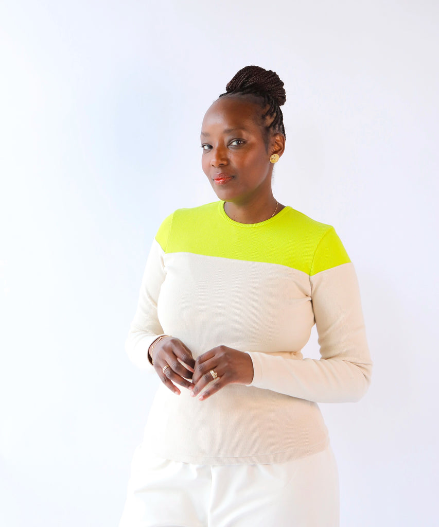 Woman wearing a color-blocked ribbed cotton long sleeve top with neon at the top, beige at the bottom