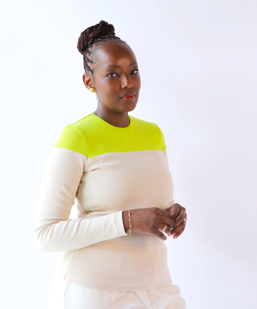 Woman wearing a color-blocked ribbed cotton long sleeve top with neon at the top, beige at the bottom