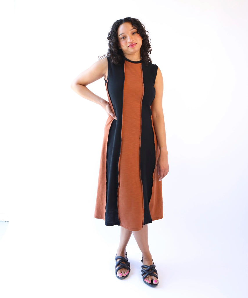 Woman wearing a sleeveless cotton midi dress with black and brown color block design