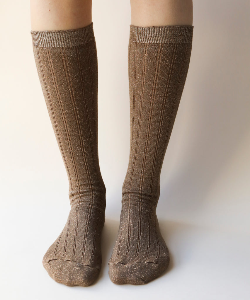 A front view of pair of cotton and nylon knee highs in a sparkly copper colour worn on a model