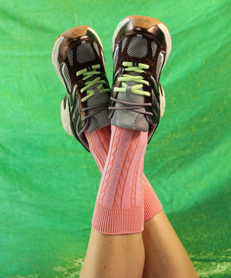 A pair of unisex, lightweight cable dressy cotton socks in coral made in Canada by Toronto brand OkayOk styled with sneakers