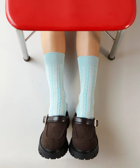A pair of unisex, lightweight cable dressy cotton socks in light turquoise made in Canada by Toronto brand OkayOk styled with brown brogues