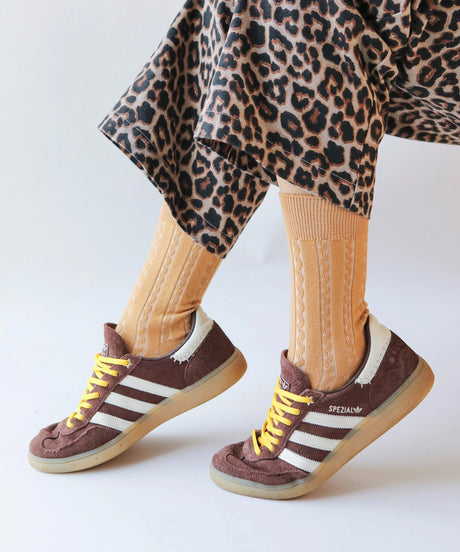A pair of unisex, lightweight cable dressy cotton socks in toast beige made in Canada by Toronto brand OkayOk styled with brown sneakers