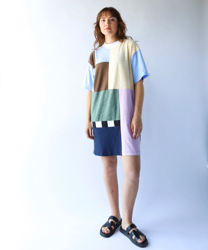 Woman wearing a colorful patchwork quilted tshirt dress in soft colours