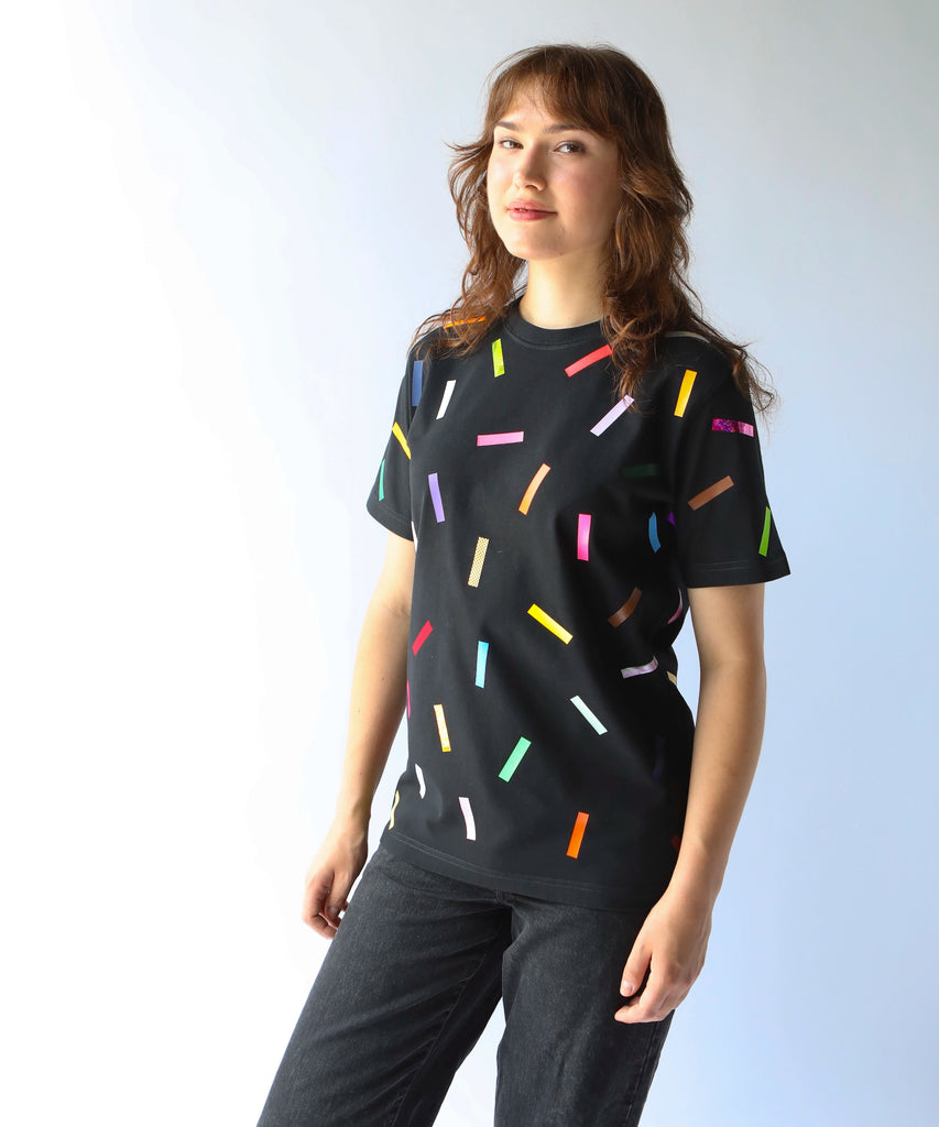 Woman wearing a black cotton t-shirt with colorful confetti sprinkles on it