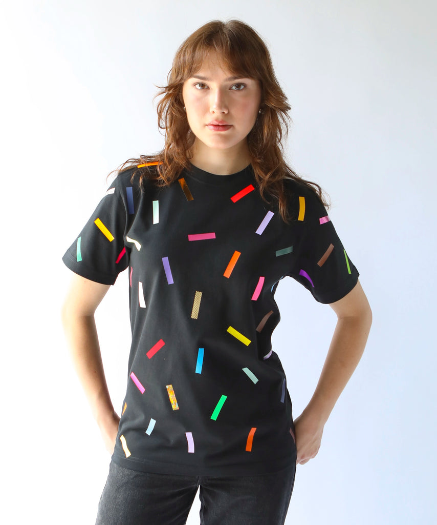Woman wearing a black cotton t-shirt with colorful confetti sprinkles on it