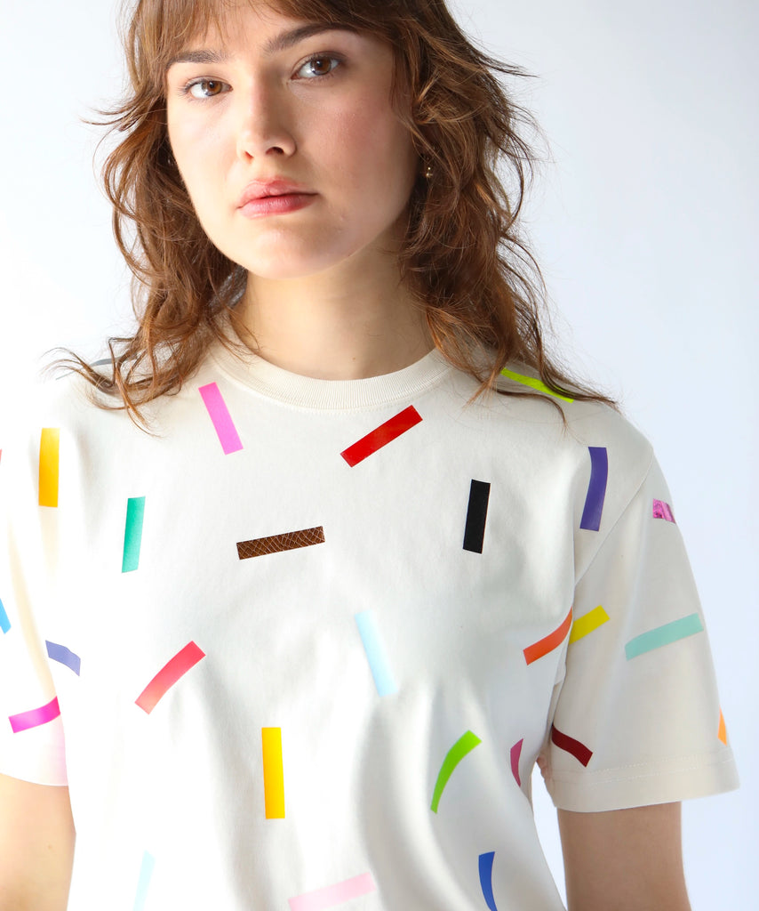 Woman wearing a cream cotton t-shirt with colorful confetti sprinkles on it