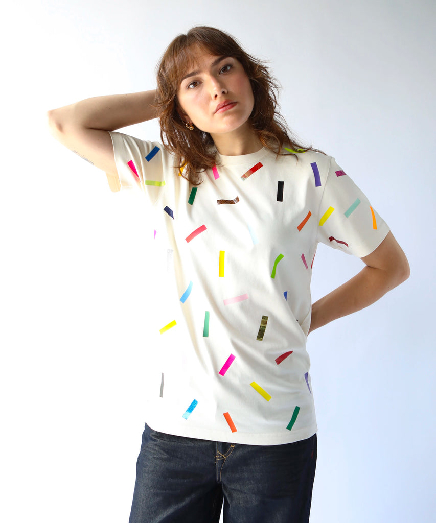 Woman wearing a cream cotton t-shirt with colorful confetti sprinkle pattern on it 