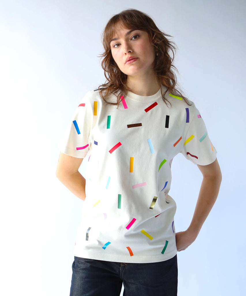 Woman wearing a cream cotton t-shirt with colorful confetti sprinkles on it