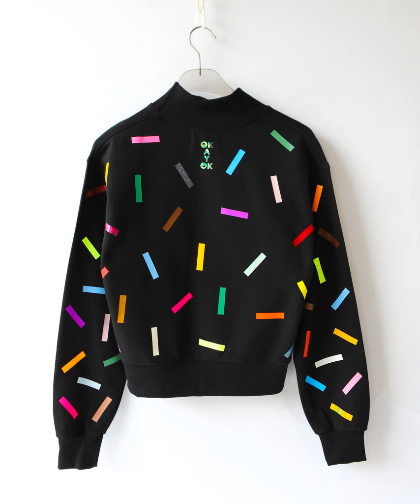 High neck black cotton sweater with colorful confetti sprinkle pattern