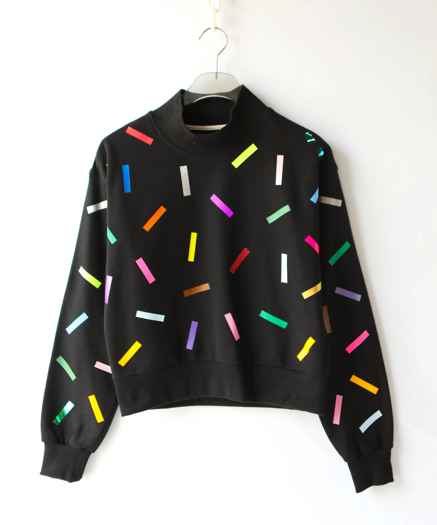 High neck black cotton sweater with colorful confetti sprinkle pattern