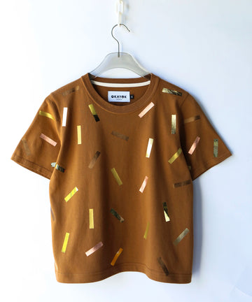 a boxy cotton tshirt in tobacco brown with gold confetti sprinkle graphic print