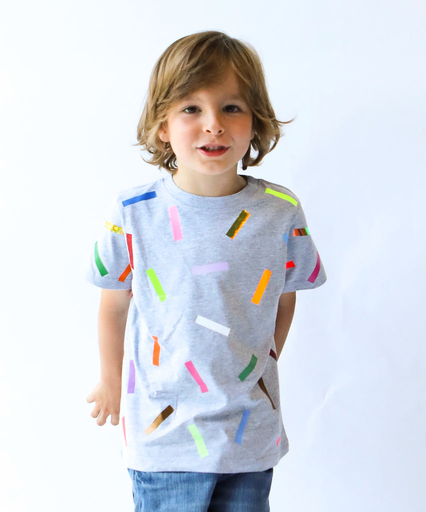 Child wearing a gray cotton t-shirt with colorful sprinkle confetti pattern
