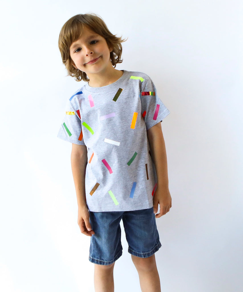 Child wearing a gray cotton t-shirt with colorful sprinkle confetti pattern