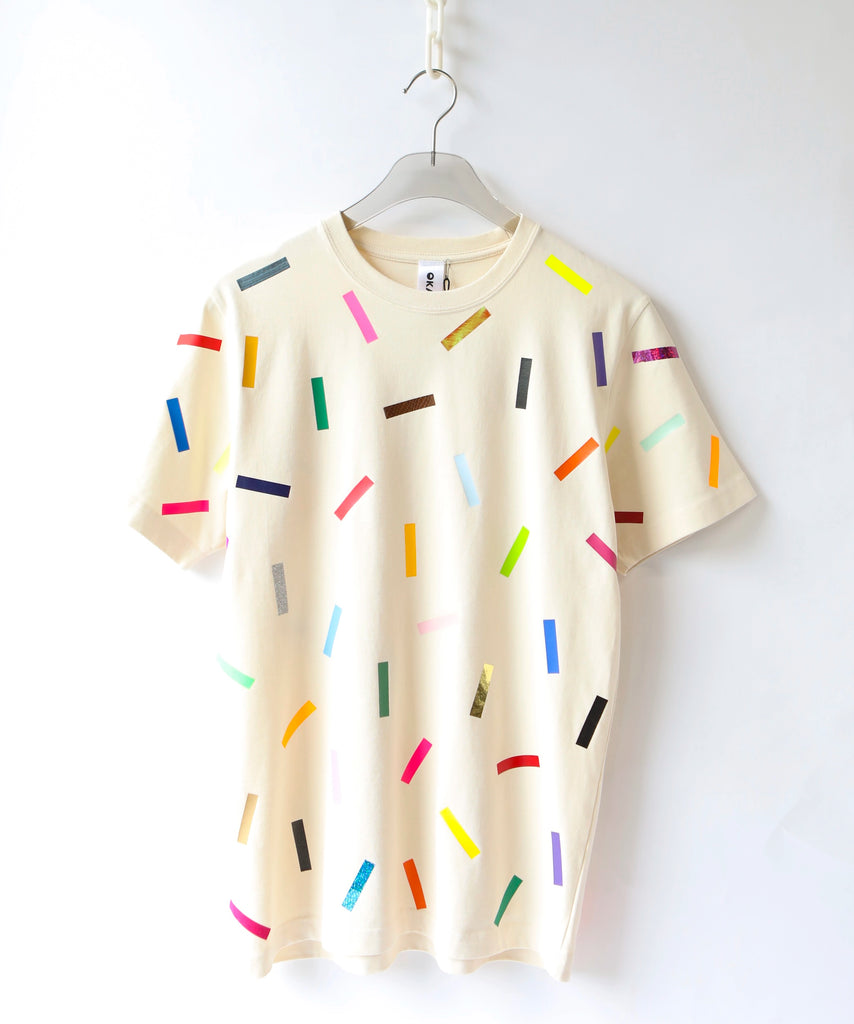 a cream cotton t-shirt with colorful confetti sprinkle pattern on it 