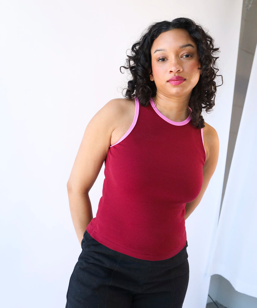 Woman wearing a red ribbed cotton tank top with pink trim