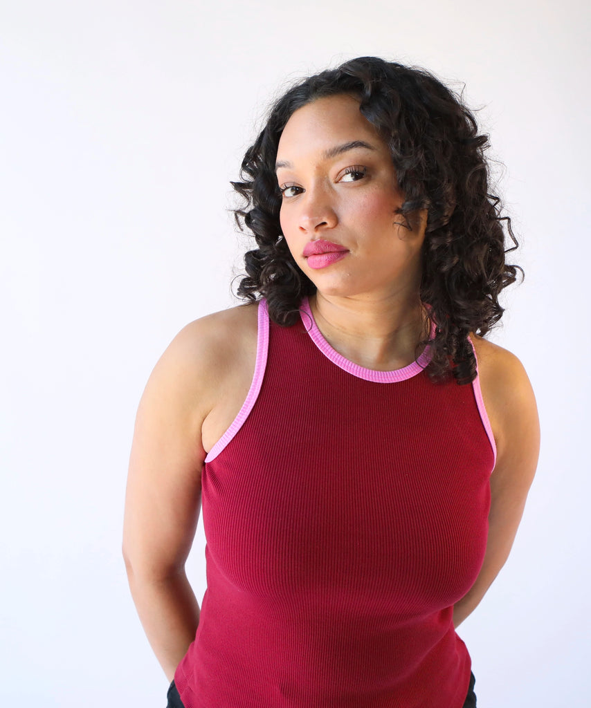 Woman wearing a red ribbed cotton tank top with pink trim