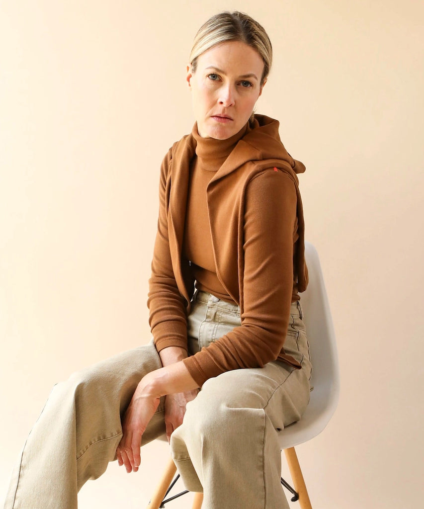 a woman wears a long sleeve 100% cotton turtleneck tshirt in brown