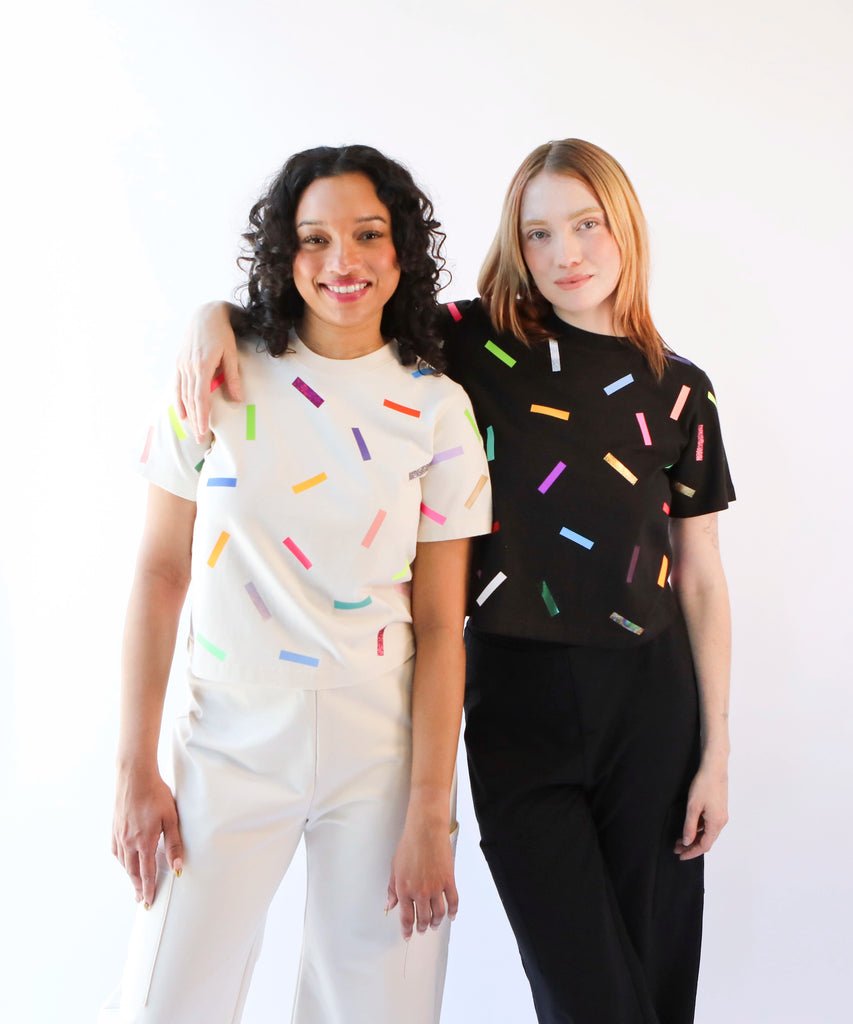two women wearing a cotton t-shirt with colorful confetti sprinkles pattern in cream and black