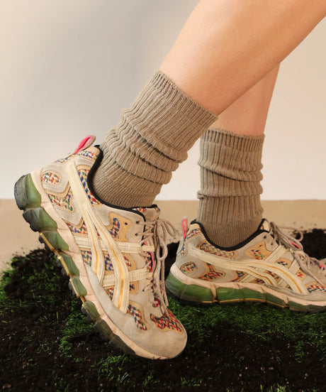 A pair of unisex ribbed crew cotton socks in khaki beige made in Canada by Toronto brand OkayOk styled with sneakers