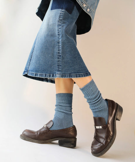 A pair of unisex ribbed crew cotton socks in faded blue made in Canada by Toronto brand OkayOk styled with brown loafers