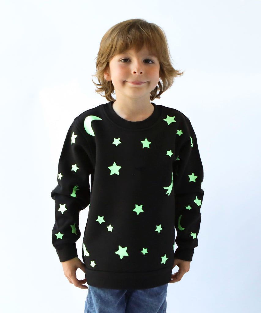 child wearing glow in the dark star and moon printed cotton sweatshirt in black