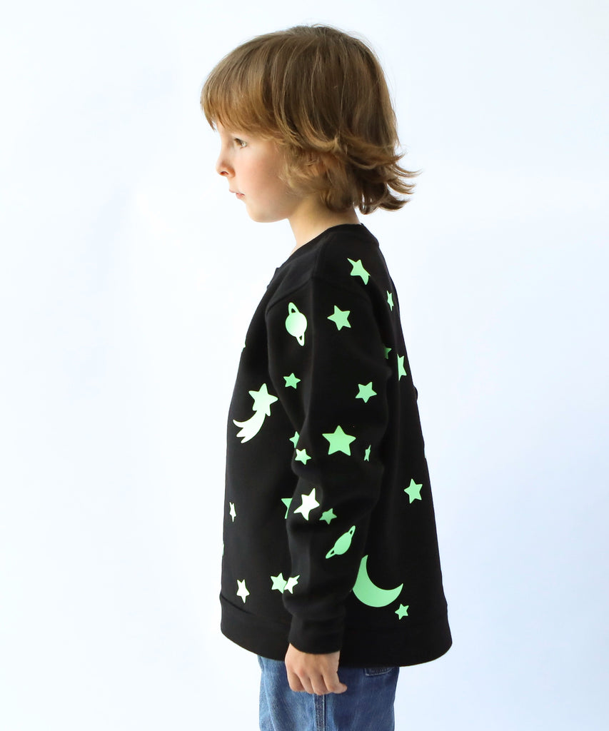 child wearing glow in the dark star and moon printed cotton sweatshirt in black