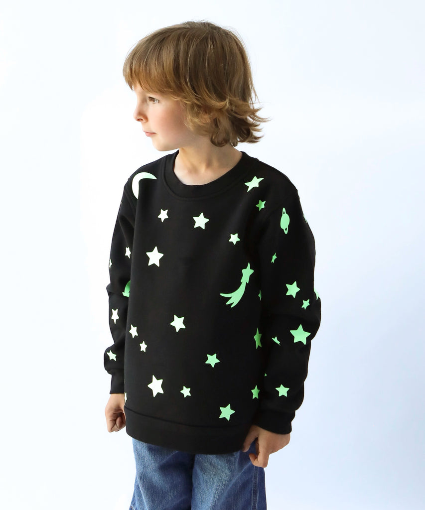 child wearing glow in the dark star and moon printed cotton sweatshirt in black