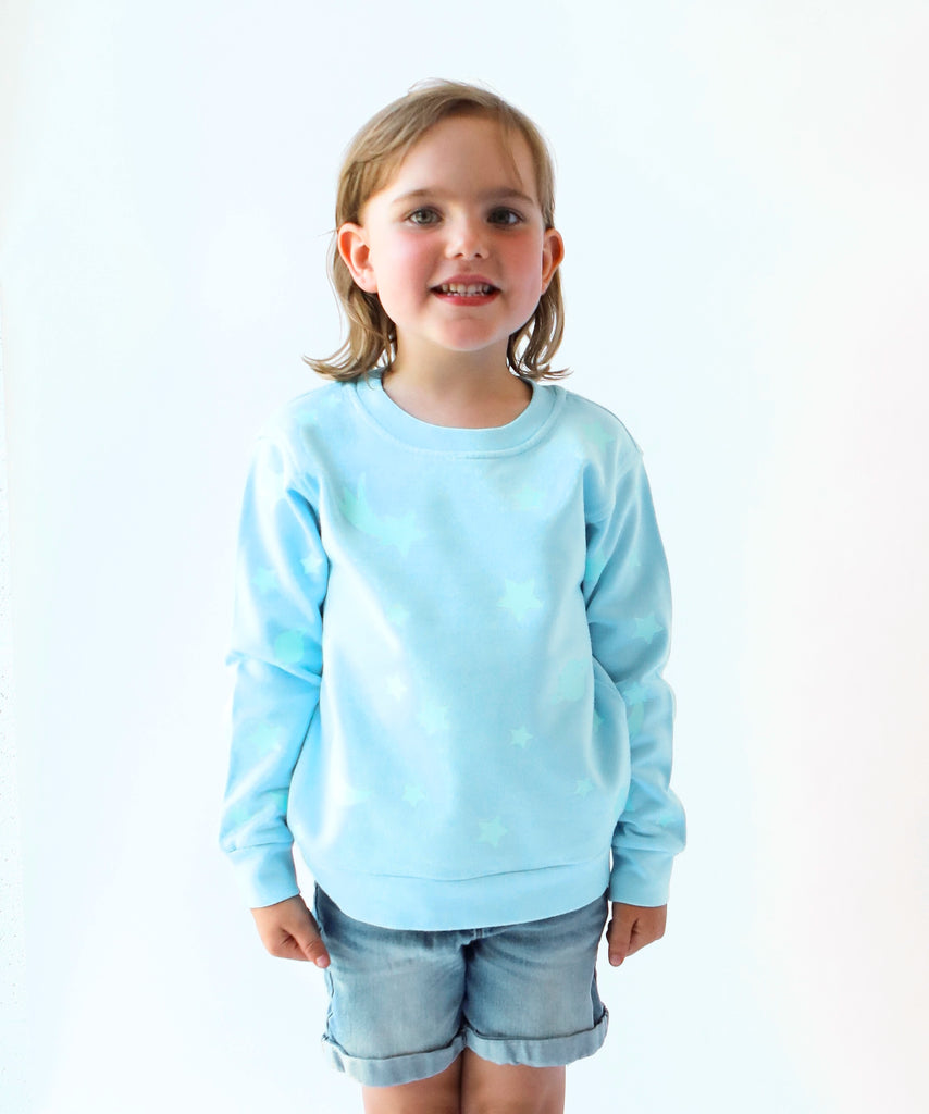 child wearing glow in the dark star printed cotton sweatshirt in light blue