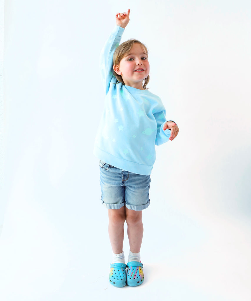 child wearing glow in the dark star printed cotton sweatshirt in light blue