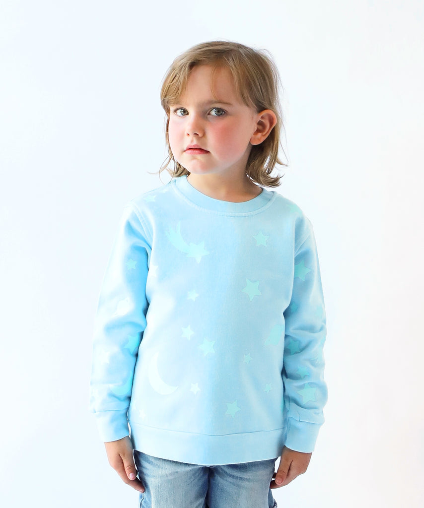 child wearing glow in the dark star printed cotton sweatshirt in light blue