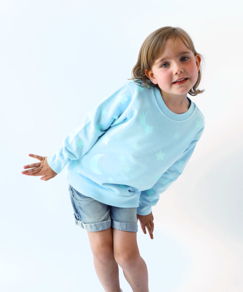 child wearing glow in the dark star printed cotton sweatshirt in light blue