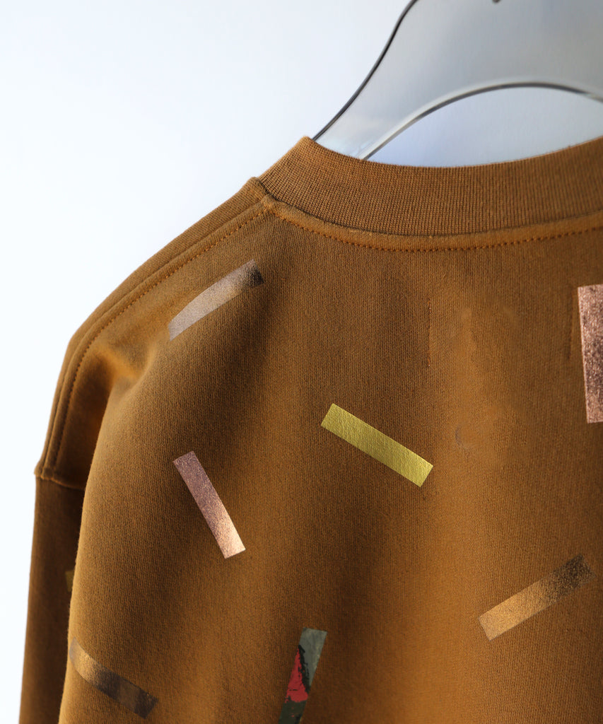 Brown sweatshirt with gold and bronze confetti sprinkle print design and 'OKAYOK' text 