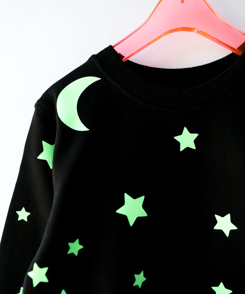 a close up of glow in the dark star and moon printed cotton sweatshirt in black