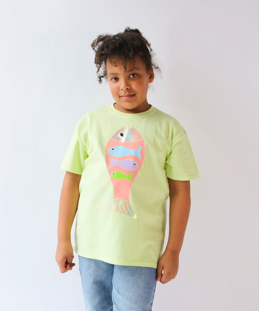 Child wearing a light green cotton t-shirt with a colorful fish design in pastel colours