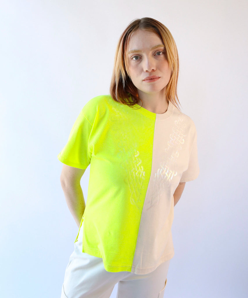 Woman wearing a two-tone shirt in neon yellow and beige with a clear knotted design on top