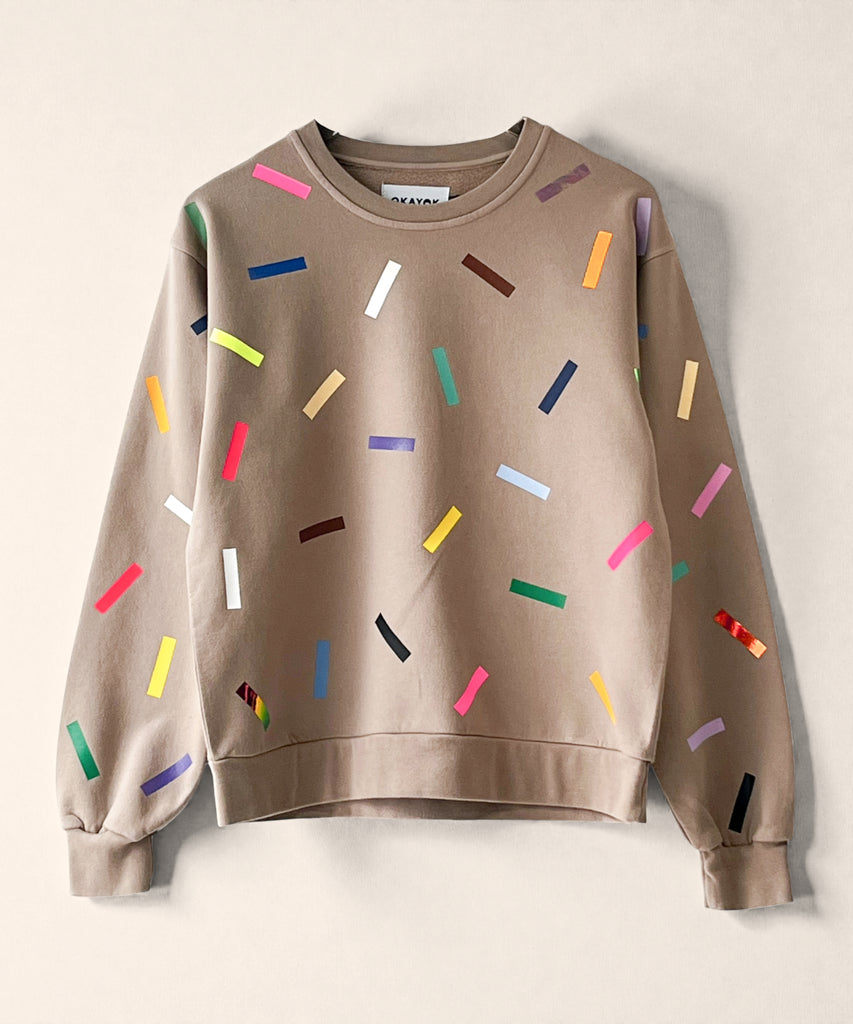 A 100% cotton sweatshirt in taupe with colourful confetti sprinkle graphic print