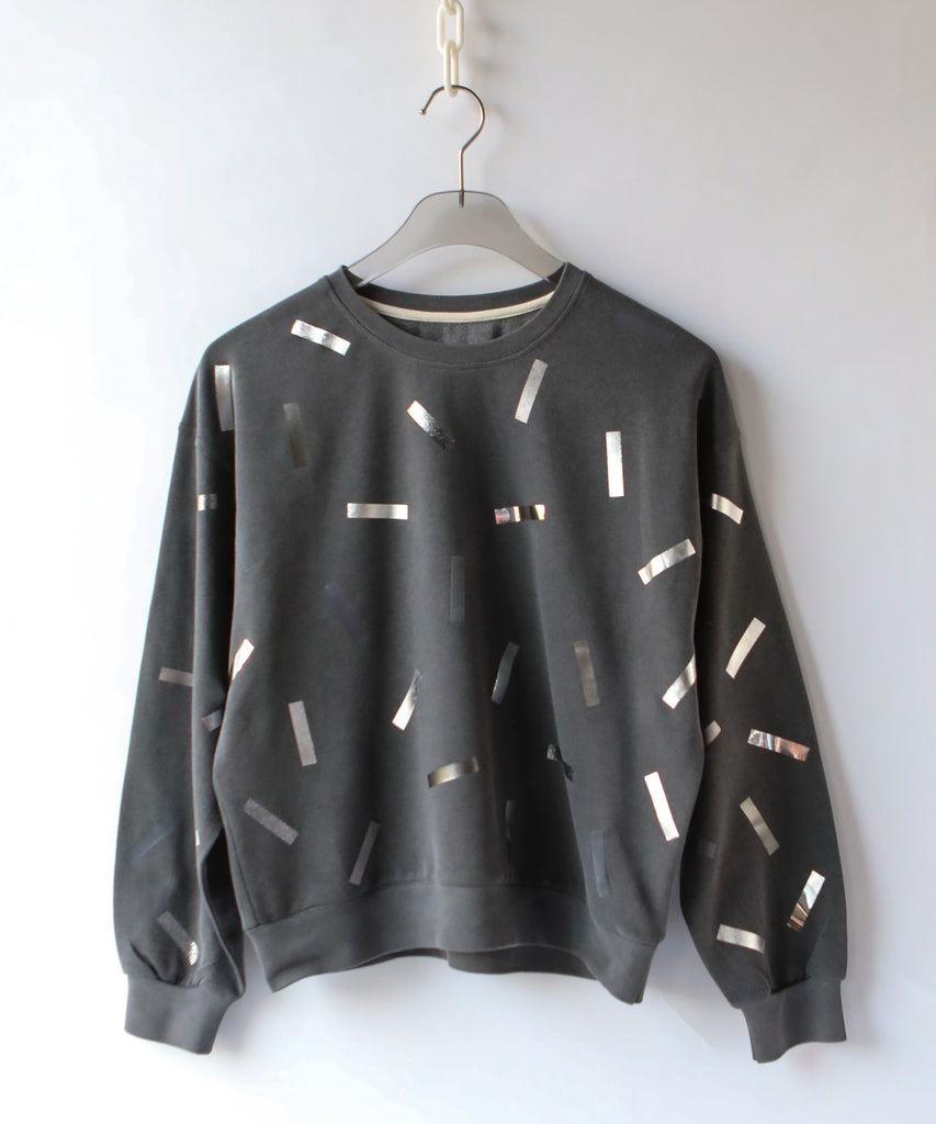 a cotton sweatshirt in dark grey with silver confetti sprinkle graphic print