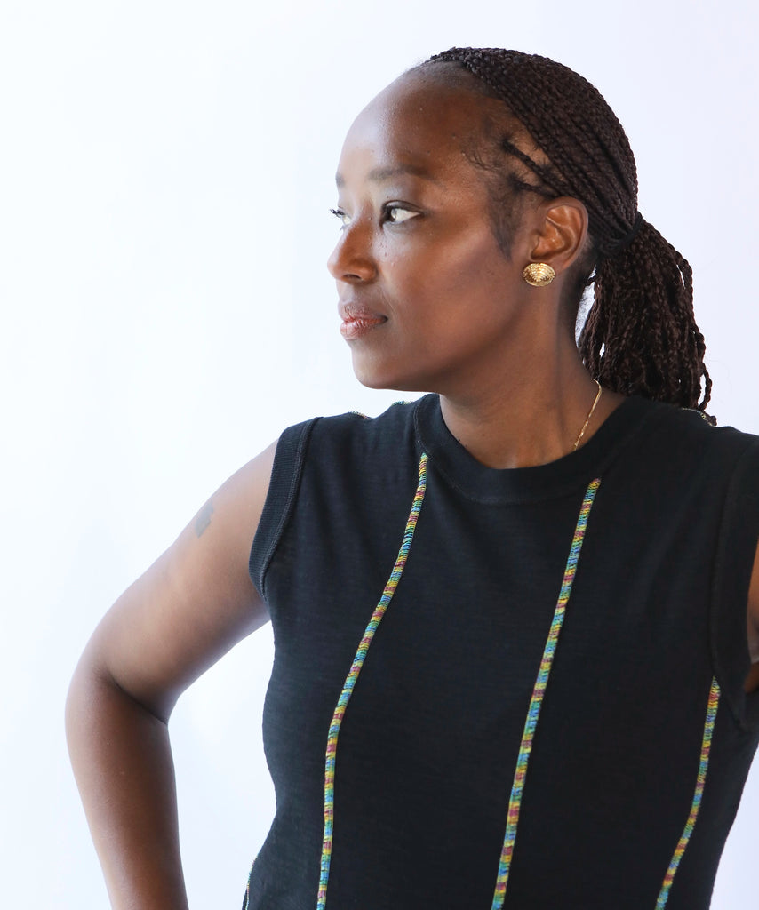 Woman wearing a black sleeveless cotton dress with multicolor trim