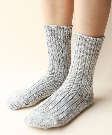 a pair of feet wearing thick cotton socks in grey made in Canada by Toronto brand Okayok