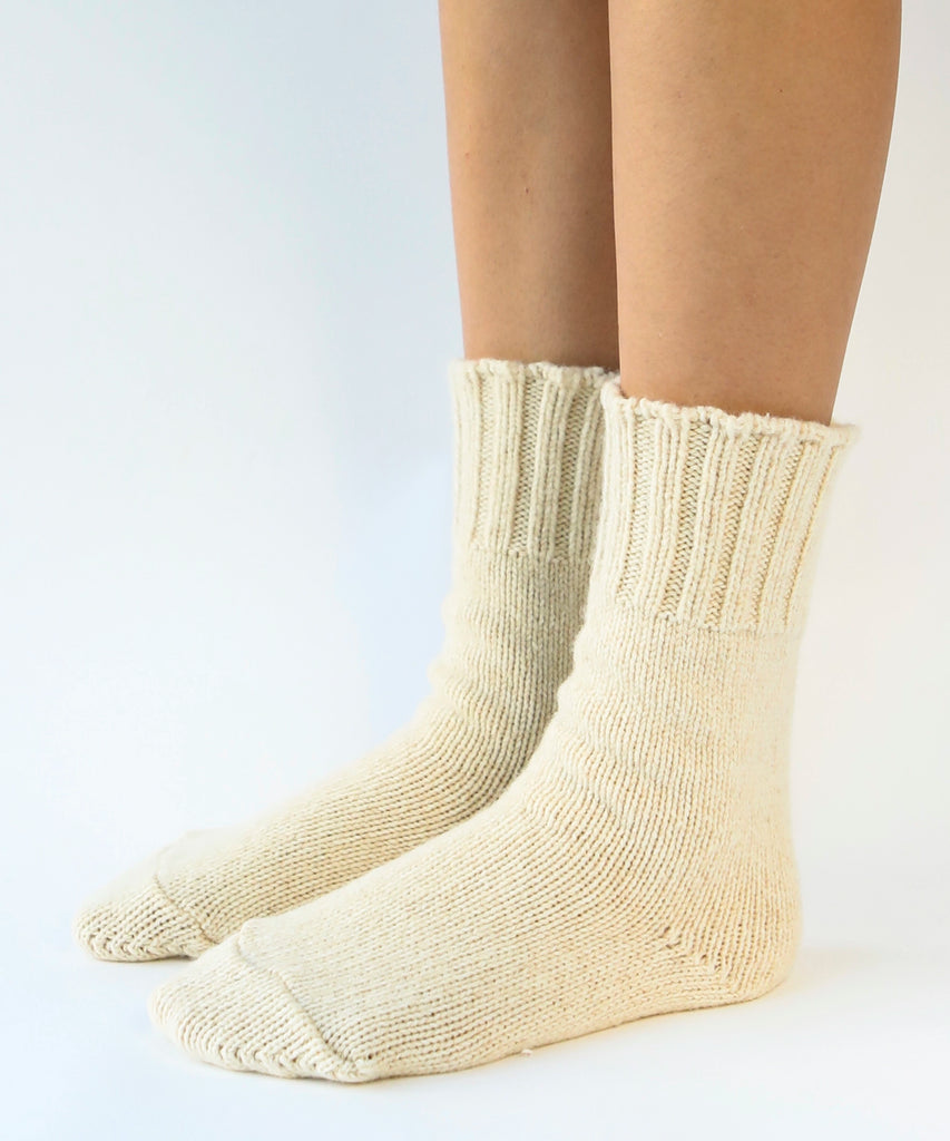 person wearing pair of wool knit socks in cream
