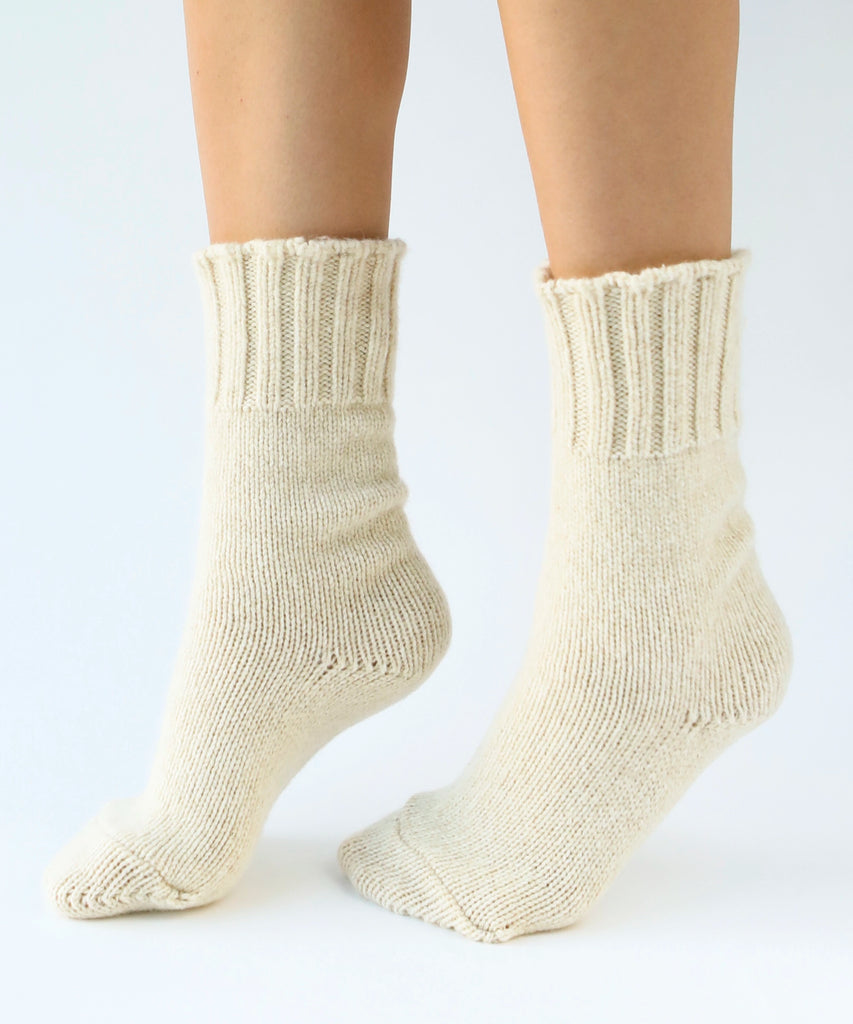 person wearing pair of wool knit socks in cream