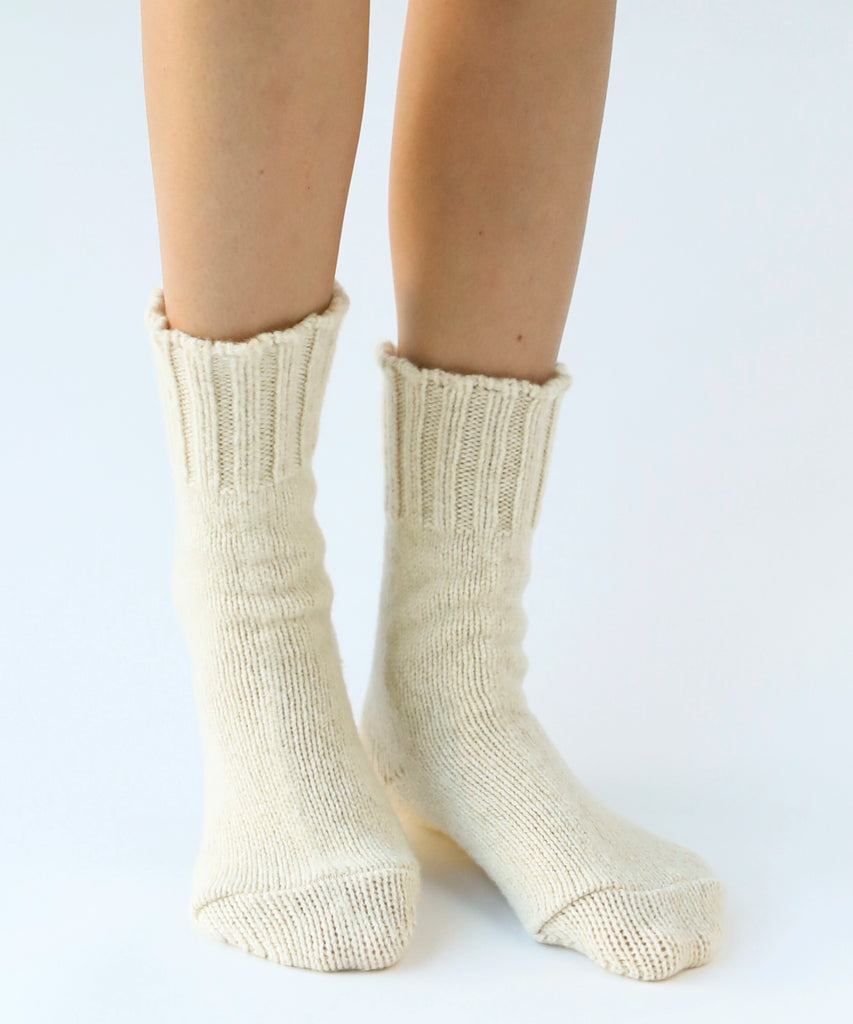 person wearing pair of wool knit socks in cream