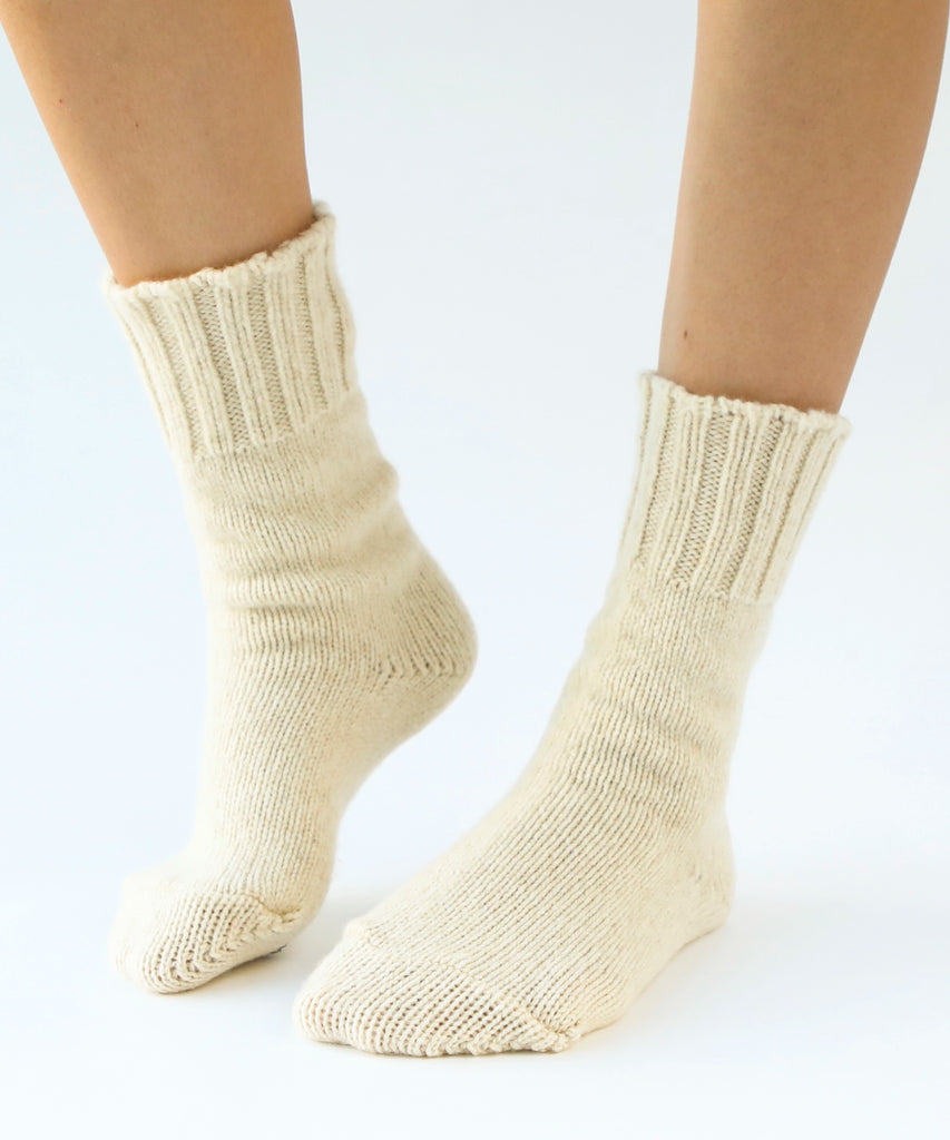 person wearing pair of wool knit socks in cream