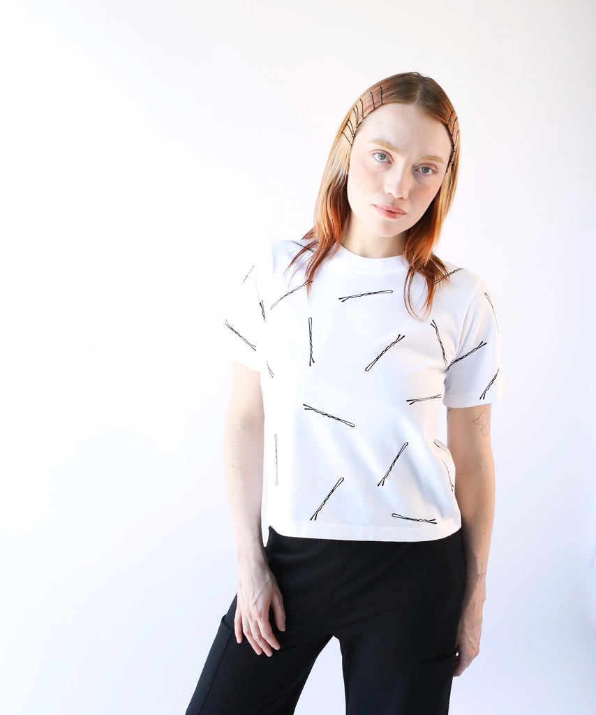 Woman wearing a white cotton t-shirt with black bobby pin pattern