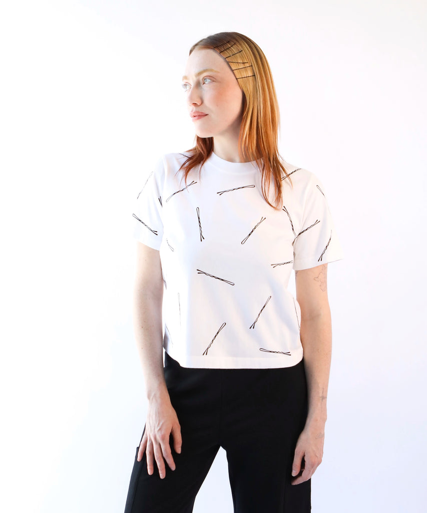 Woman wearing a white cotton t-shirt with black bobby pin pattern
